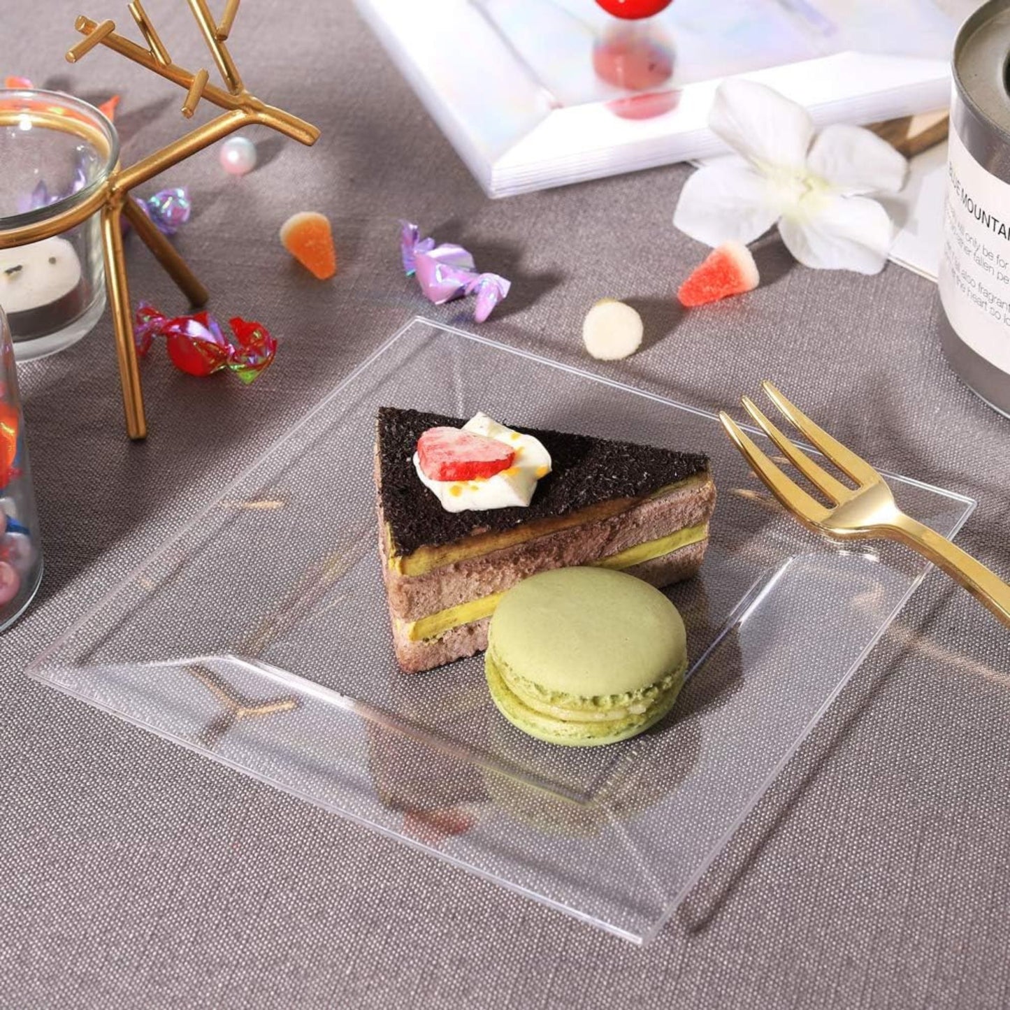 Small dessert plate with a slice of cake and macaron on a gray surface.