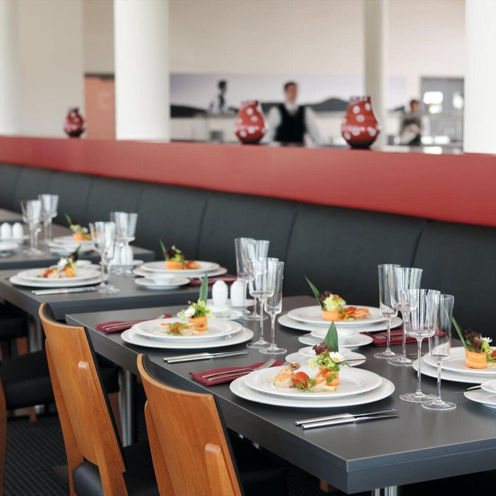 Dining table set with plates, glasses, and cutlery in a restaurant setting.