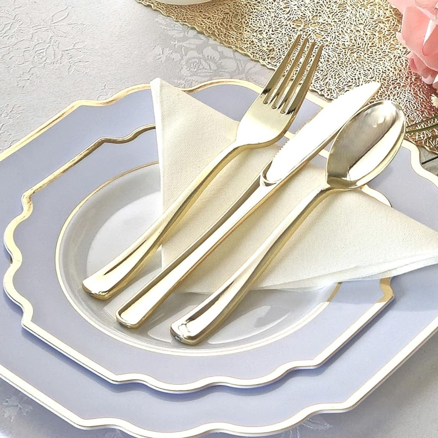 Gold cutlery set on a white plate with a decorative napkin